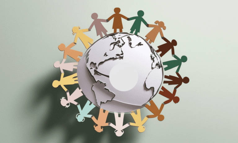 Paper cutouts of diverse people holding hands form a circle around a globe, symbolizing global unity and connectedness.